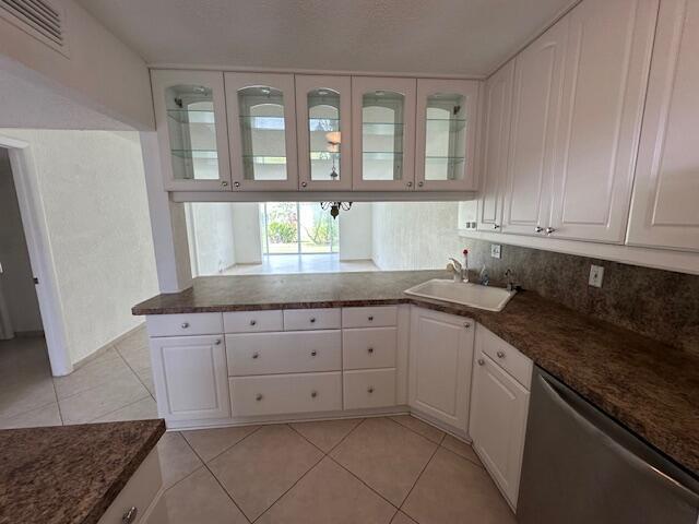 A kitchen features white cabinets, brown laminate countertops, a white sink, and tile flooring — 21 Abbey Lane # 107, Delray Beach FL 33446, DELRAY BEACH, FL