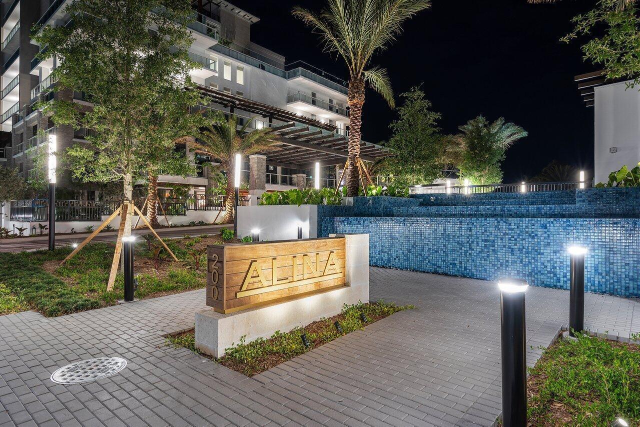 A bright, open-concept living and dining area features white cabinetry, modern furniture, and floor-to-ceiling windows — 210 SE Mizner Boulevard # 301, Boca Raton FL 33432, BOCA RATON, FL