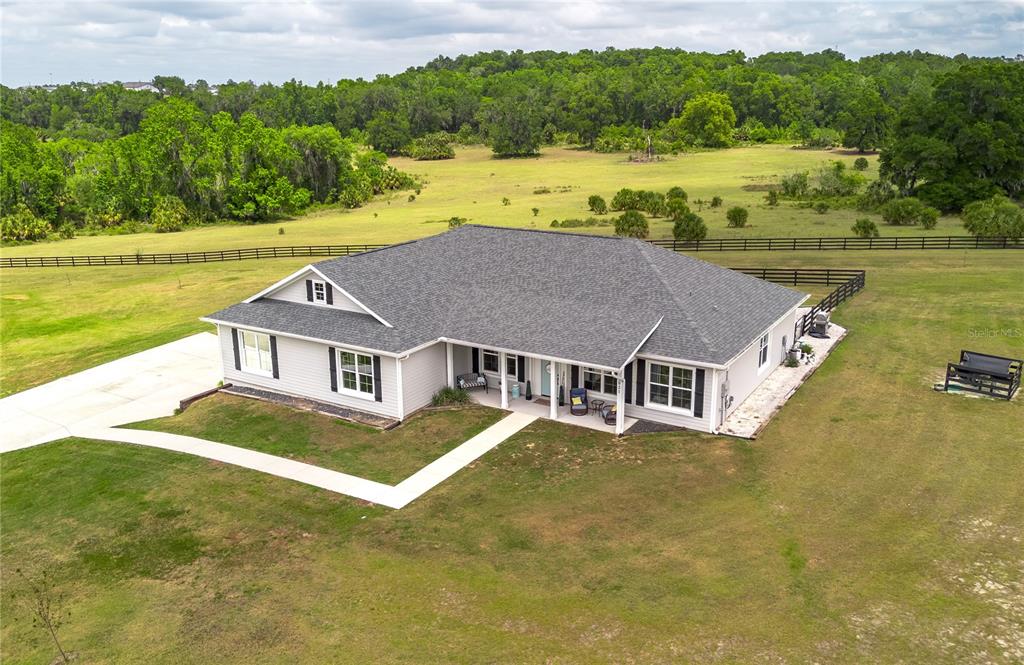 An aerial view shows a single-story house with a gray roof and light siding — 5021 NW 101ST STREET ROAD, OCALA, FL