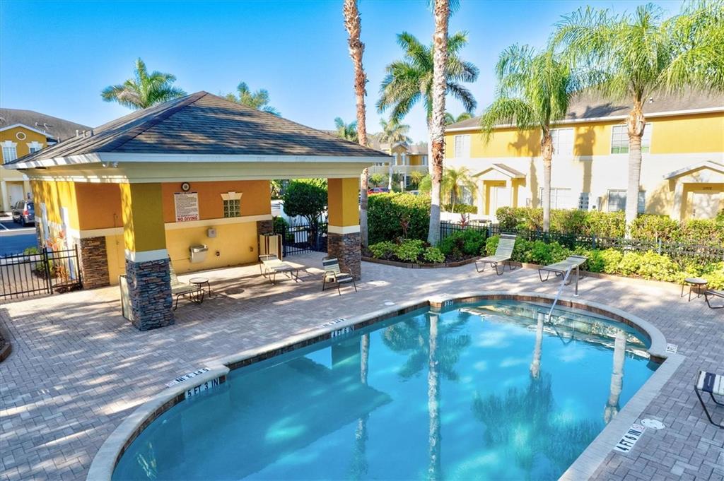 An outdoor swimming pool with a covered patio area and lounge chairs — 13088 TIGERS EYE DRIVE, VENICE, FL