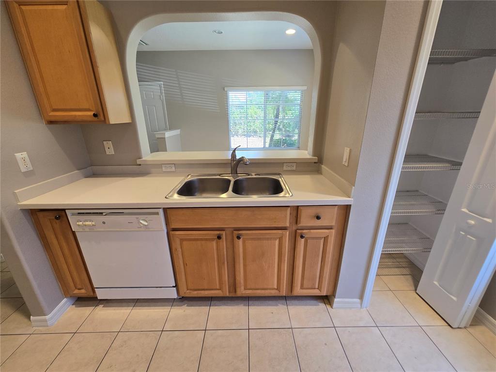 A kitchen features light wood cabinets, white appliances, a double sink, and a walk-in pantry — 13088 TIGERS EYE DRIVE, VENICE, FL