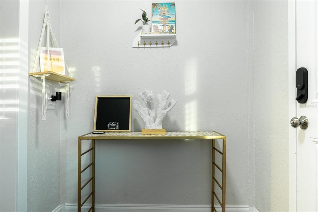 A gold console table sits against a light gray wall in an entryway — 4327 17TH AVENUE S, ST PETERSBURG, FL