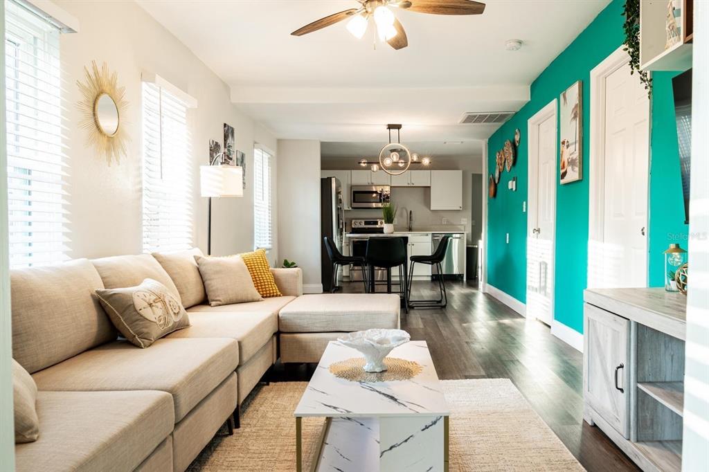 A living room with a beige sectional sofa, marble coffee table, and a teal accent wall — 4327 17TH AVENUE S, ST PETERSBURG, FL