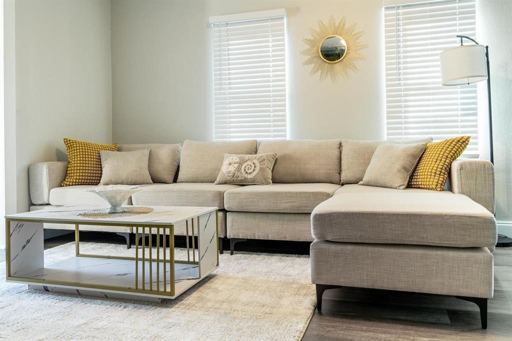 A living room features a beige sectional sofa, a marble-topped coffee table, and two windows — 4327 17TH AVENUE S, ST PETERSBURG, FL
