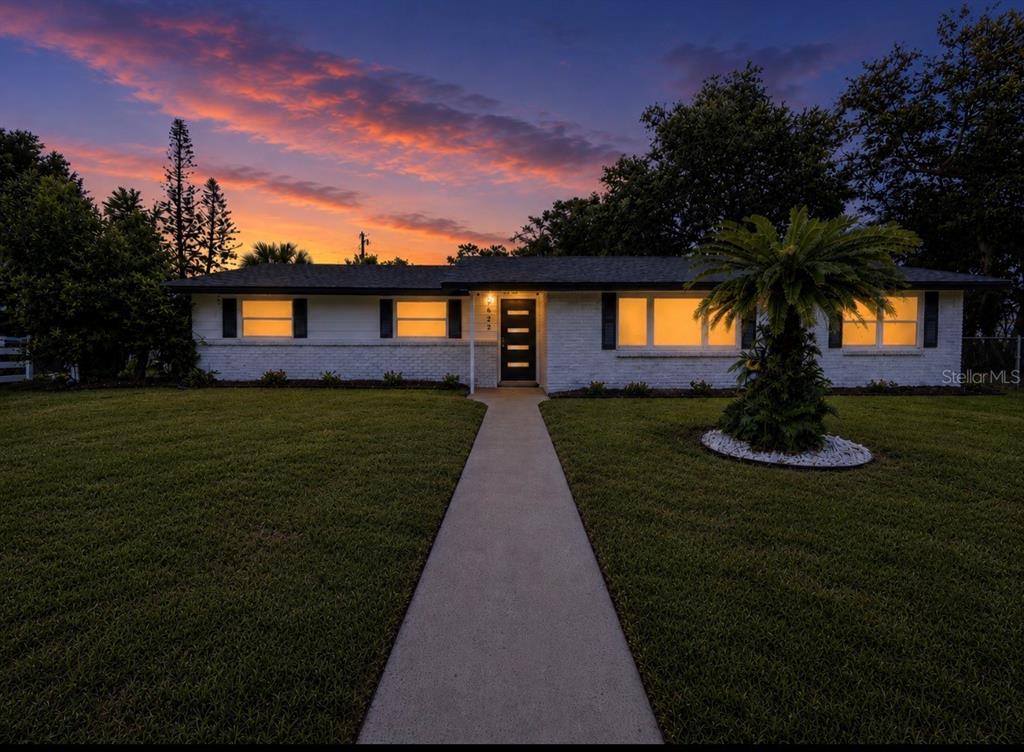 A single-story white brick house with a front walkway and palm tree at sunset — 3629 S CRYSTAL LAKE DRIVE, ORLANDO, FL