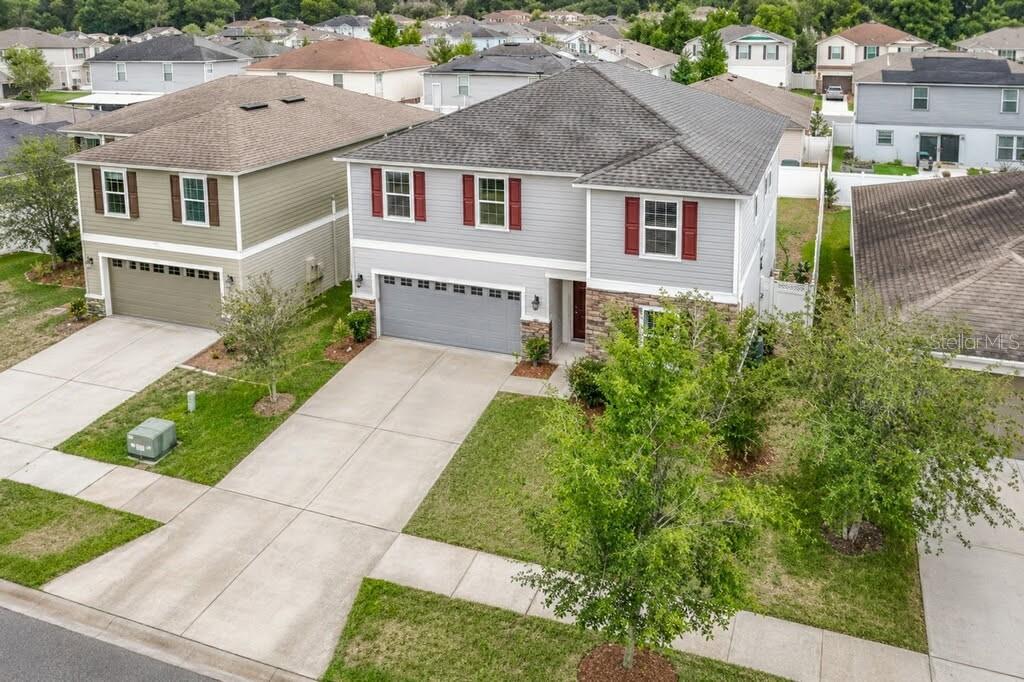 An aerial view of two suburban two-story houses with driveways and lawns — 9127 FREEDOM HILL DRIVE, SEFFNER, FL