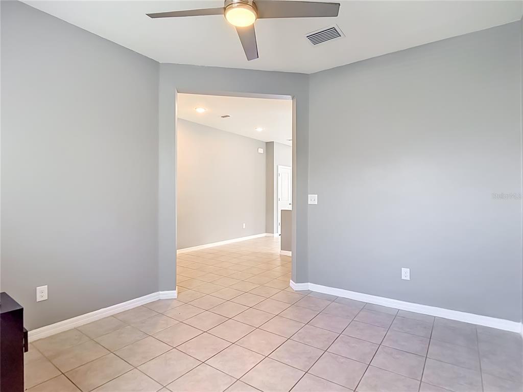 An interior room with gray walls, tiled flooring, and a ceiling fan — 9127 FREEDOM HILL DRIVE, SEFFNER, FL