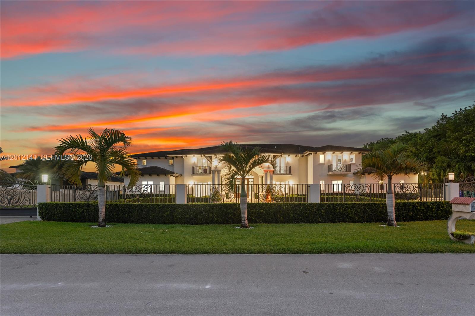 A large two-story white house with a gated yard and palm trees at sunset — 12401 SW 45th St, Miami FL 33175, MIAMI, FL