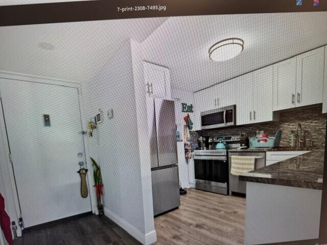 A kitchen with white cabinets, stainless steel appliances, and a dark countertop — 2308 S Cypress Bend Drive # 123, Pompano Beach FL 33069, POMPANO BEACH, FL