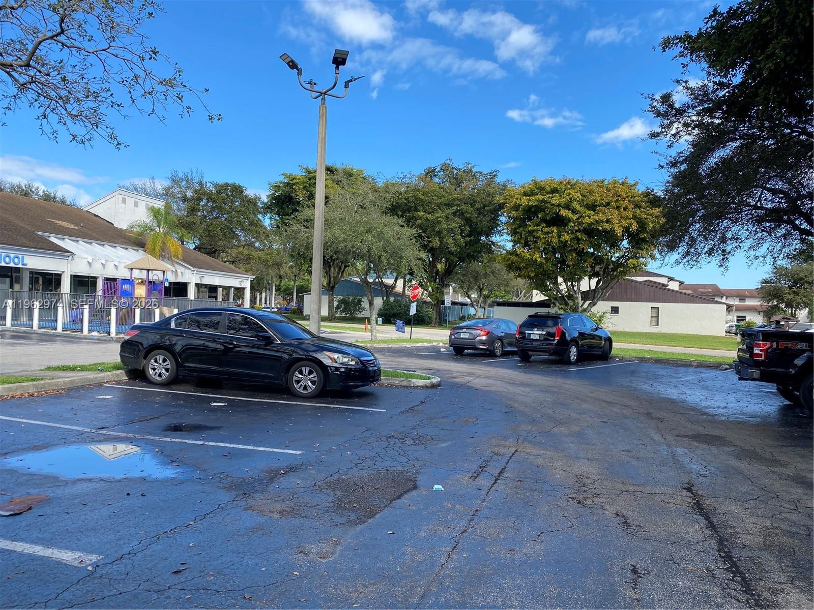 A parking lot with several parked cars sits in front of a low-rise building — 4040 SW 69th Ave, Miramar FL 33023, MIRAMAR, FL