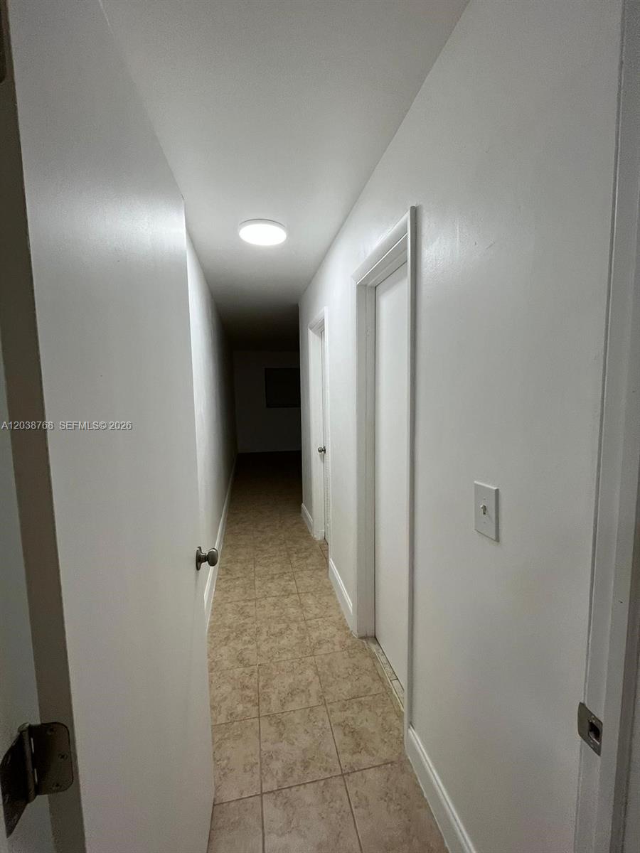 A narrow hallway features white walls, tiled flooring, and a single ceiling light fixture — 325 NE 2 # 5, Hallandale Beach FL 33009, HALLANDALE BEACH, FL