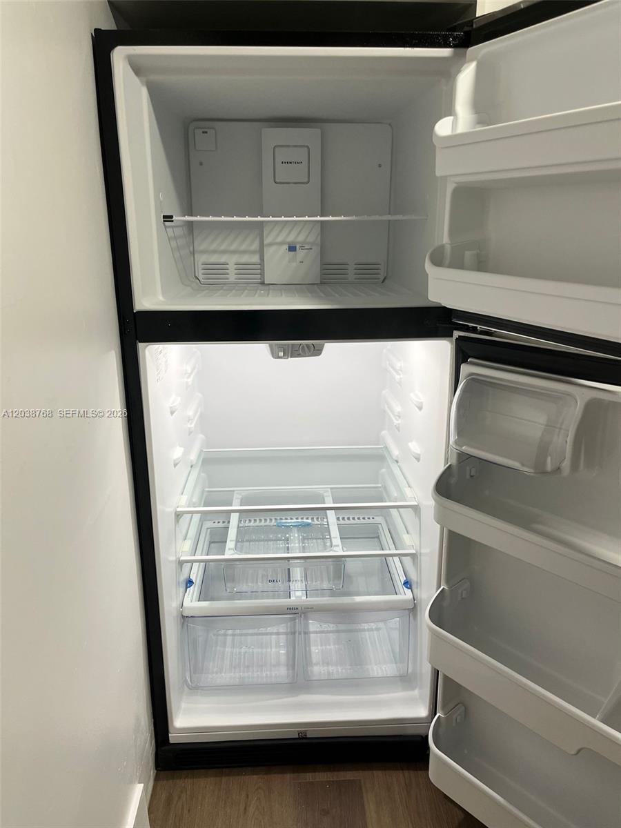 An open, empty top-freezer refrigerator with white interior shelving and door bins — 325 NE 2 # 5, Hallandale Beach FL 33009, HALLANDALE BEACH, FL