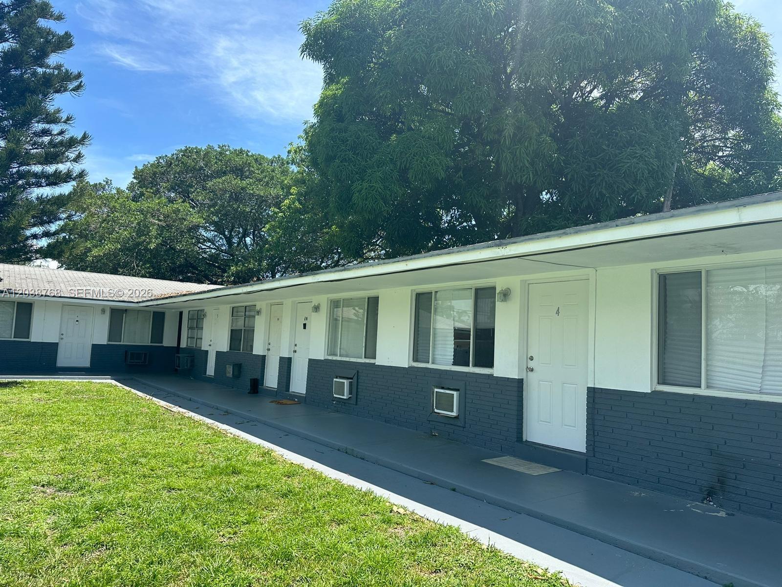 A single-story apartment building with white and gray exterior walls and a concrete walkway — 325 NE 2 # 5, Hallandale Beach FL 33009, HALLANDALE BEACH, FL