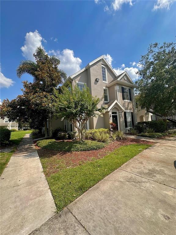 A two-story house with a tan stucco exterior, a gabled roof, and a concrete walkway — 9021 LEE VISTA BOULEVARD UNIT 1711, ORLANDO, FL