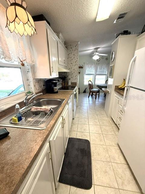 A kitchen features white cabinets, a stainless steel sink, and a tile floor — 1001 W STARKEY ROAD UNIT 475, LARGO, FL