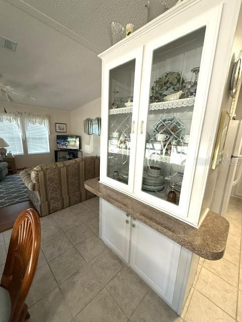 A white china cabinet with glass doors stands in a room with tile flooring — 1001 W STARKEY ROAD UNIT 475, LARGO, FL