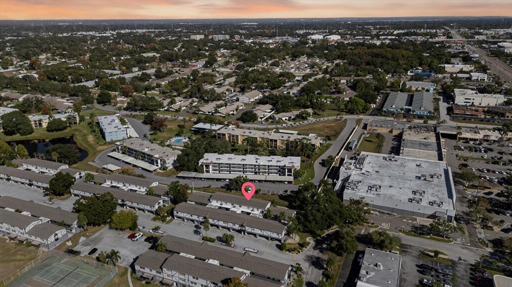 This is an aerial view of a multi-story apartment complex with a pink location pin — 1146 KING ARTHUR COURT UNIT 110, DUNEDIN, FL