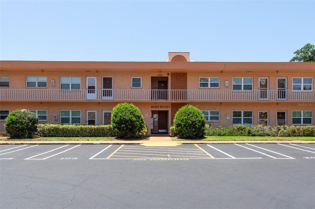 A two-story apartment building with a parking lot in the foreground — 3740 58TH STREET N UNIT 106, ST PETERSBURG, FL