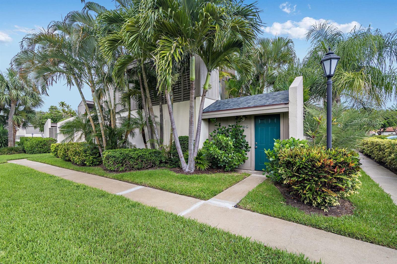 A teal front door with the number 8G is surrounded by palm trees and landscaping — 1605 S Us Highway 1 # 8g, Jupiter FL 33477, JUPITER, FL