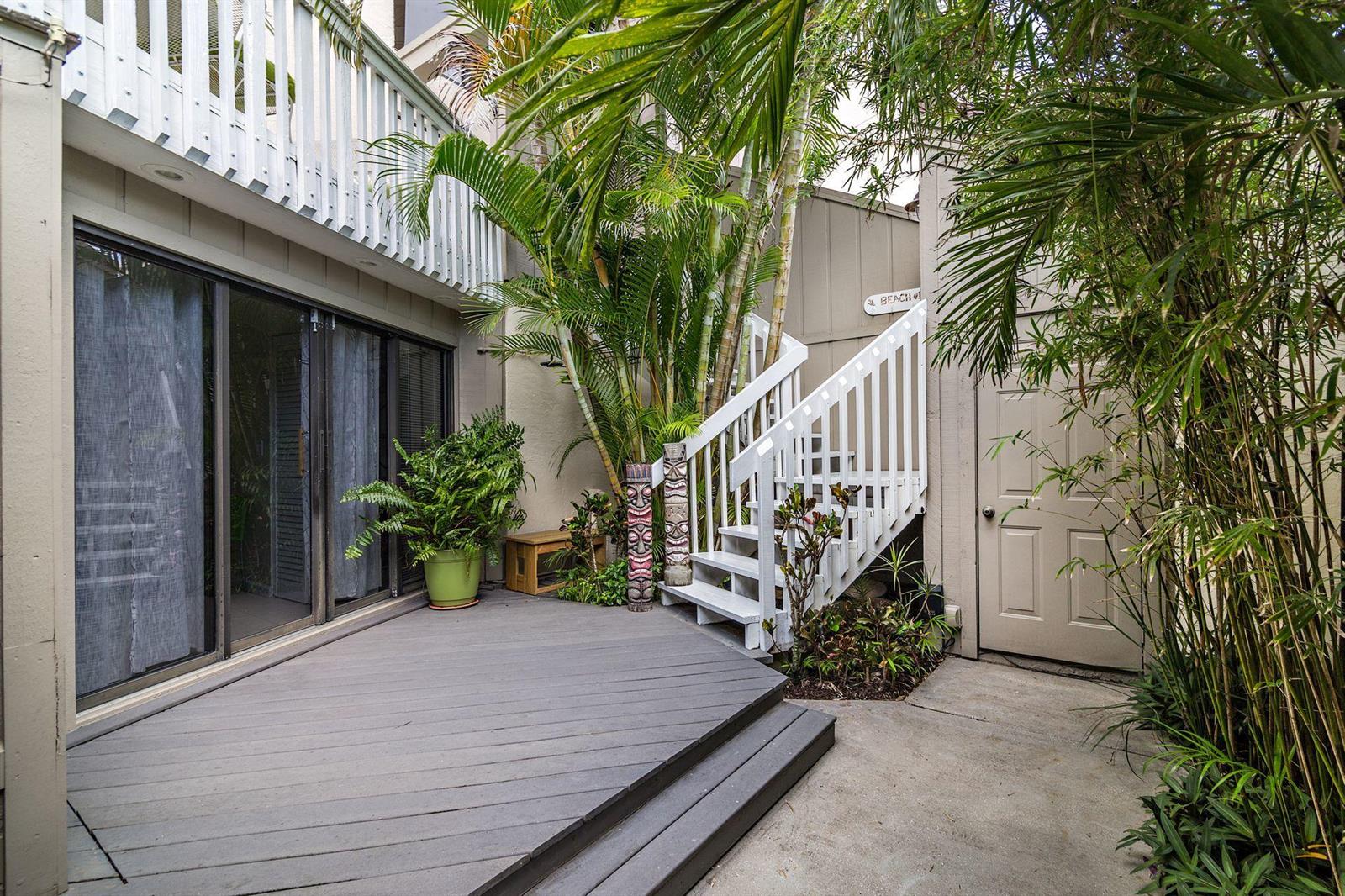 A gray wooden deck with stairs leads to a second-story balcony surrounded by lush greenery — 1605 S Us Highway 1 # 8g, Jupiter FL 33477, JUPITER, FL