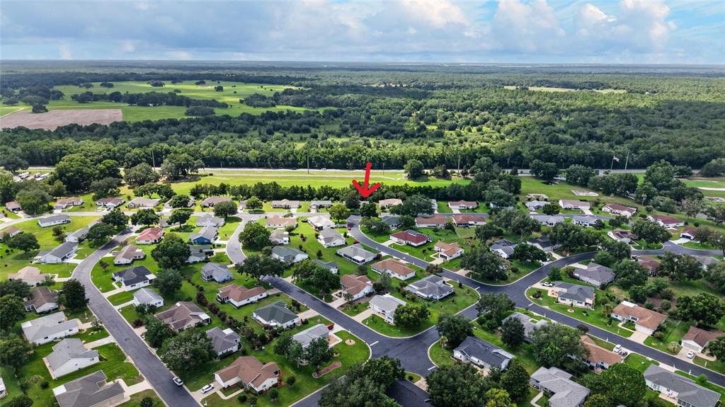 An aerial view shows a residential neighborhood with a red arrow pointing toward a house — 11946 SW 137TH LOOP, DUNNELLON, FL