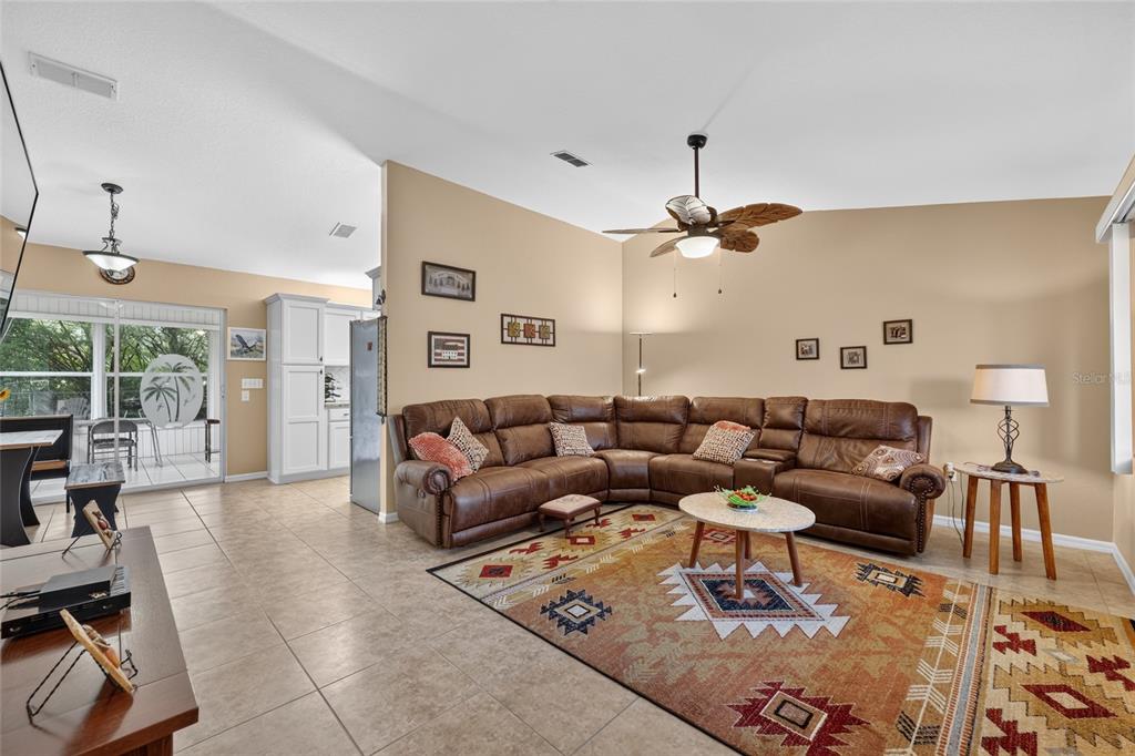 A living room features a brown sectional sofa, a patterned area rug, and tile flooring — 11946 SW 137TH LOOP, DUNNELLON, FL