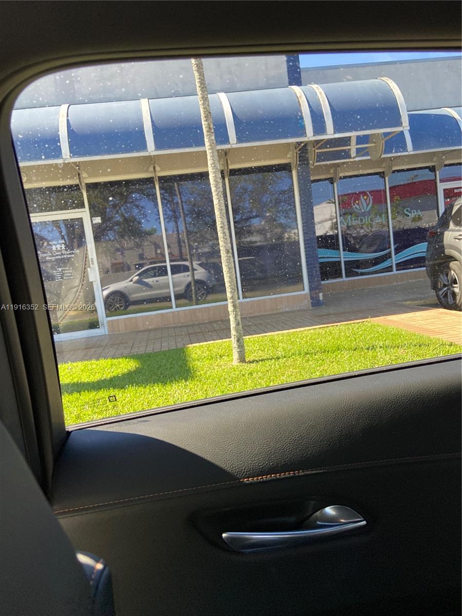 A view from a car window shows a commercial building with blue awnings and windows — 10240 SW 56th St # 105, Miami FL 33165, MIAMI, FL