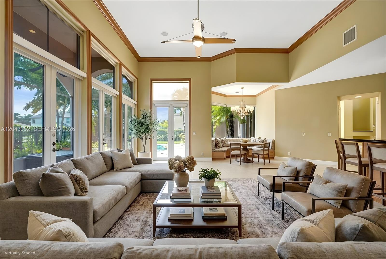 A living room with a sectional sofa, coffee table, and dining nook overlooking a pool — 9316 Pearch Ln, Boynton Beach FL 33437, BOYNTON BEACH, FL