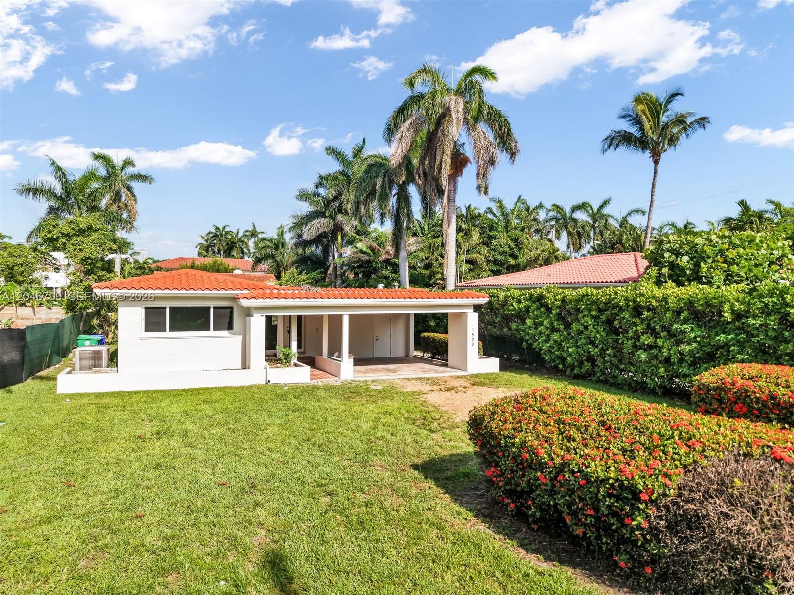 A single-story house with a red tile roof and a carport sits on a lawn — 1500 NE 13th Pl, Miami FL 33139, MIAMI, FL