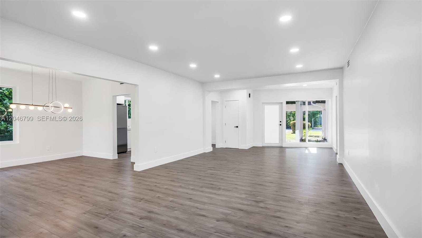 An open-concept living area features white walls, recessed lighting, and gray wood-look flooring — 1500 NE 13th Pl, Miami FL 33139, MIAMI, FL