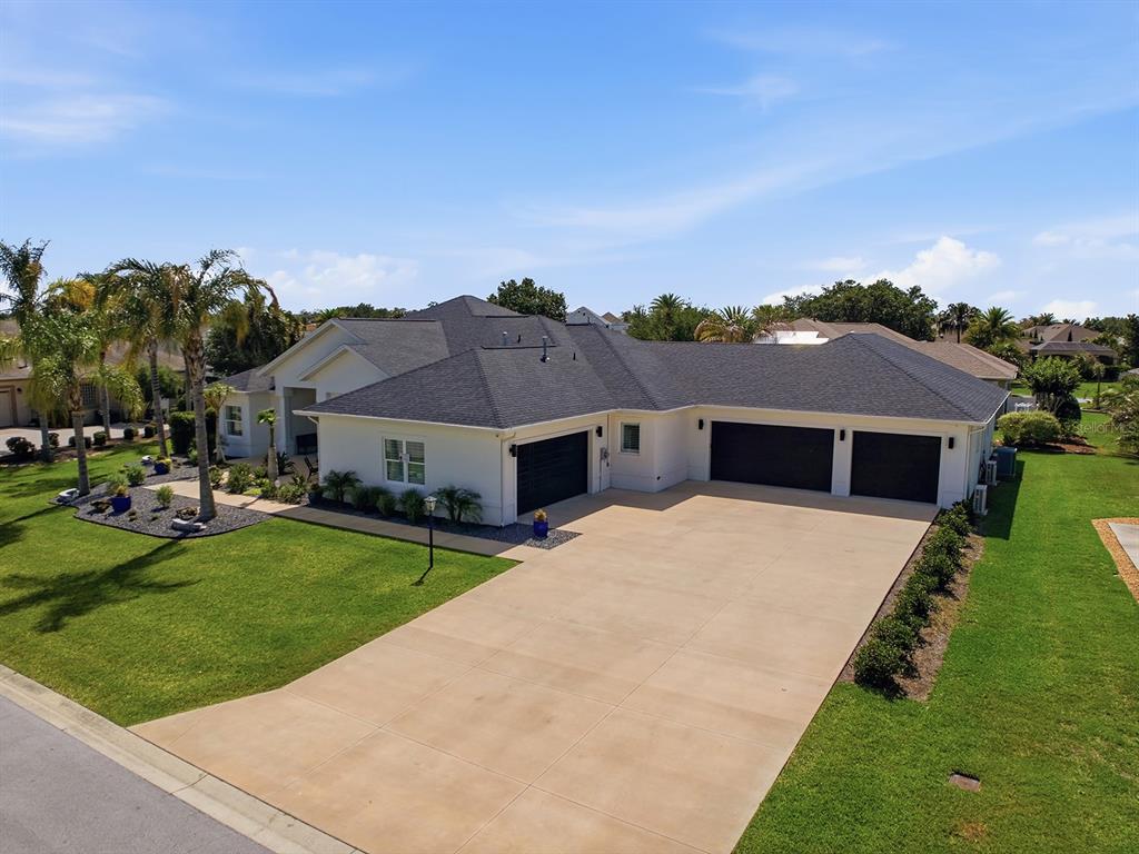 An aerial view shows a single-story house with a three-car garage and a concrete driveway — 858 PINCKNEY LANE, THE VILLAGES, FL