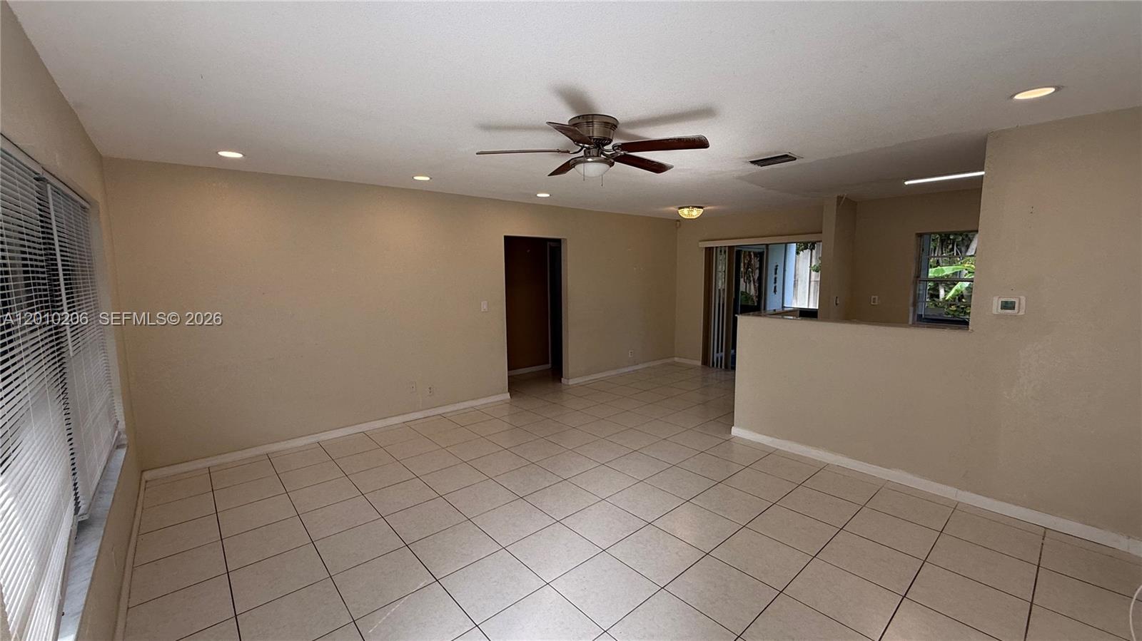 An empty living room features beige walls, light-colored tile flooring, and a ceiling fan — 3021 NW 2nd Ave, Pompano Beach FL 33064, POMPANO BEACH, FL