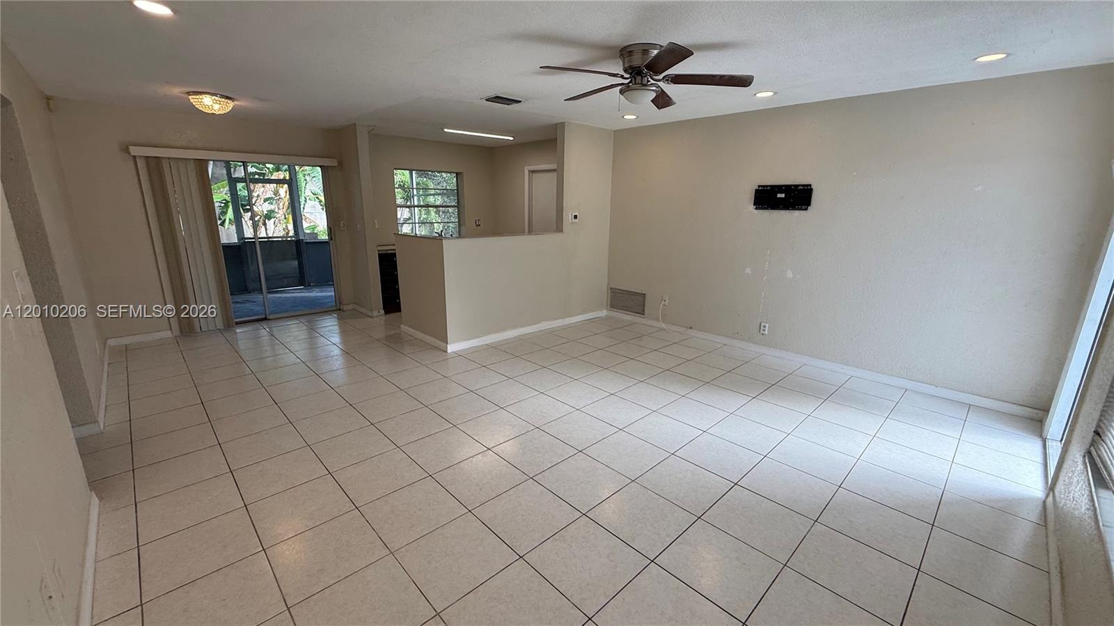 A living room with light tile flooring, a ceiling fan, and a sliding glass door — 3021 NW 2nd Ave, Pompano Beach FL 33064, POMPANO BEACH, FL