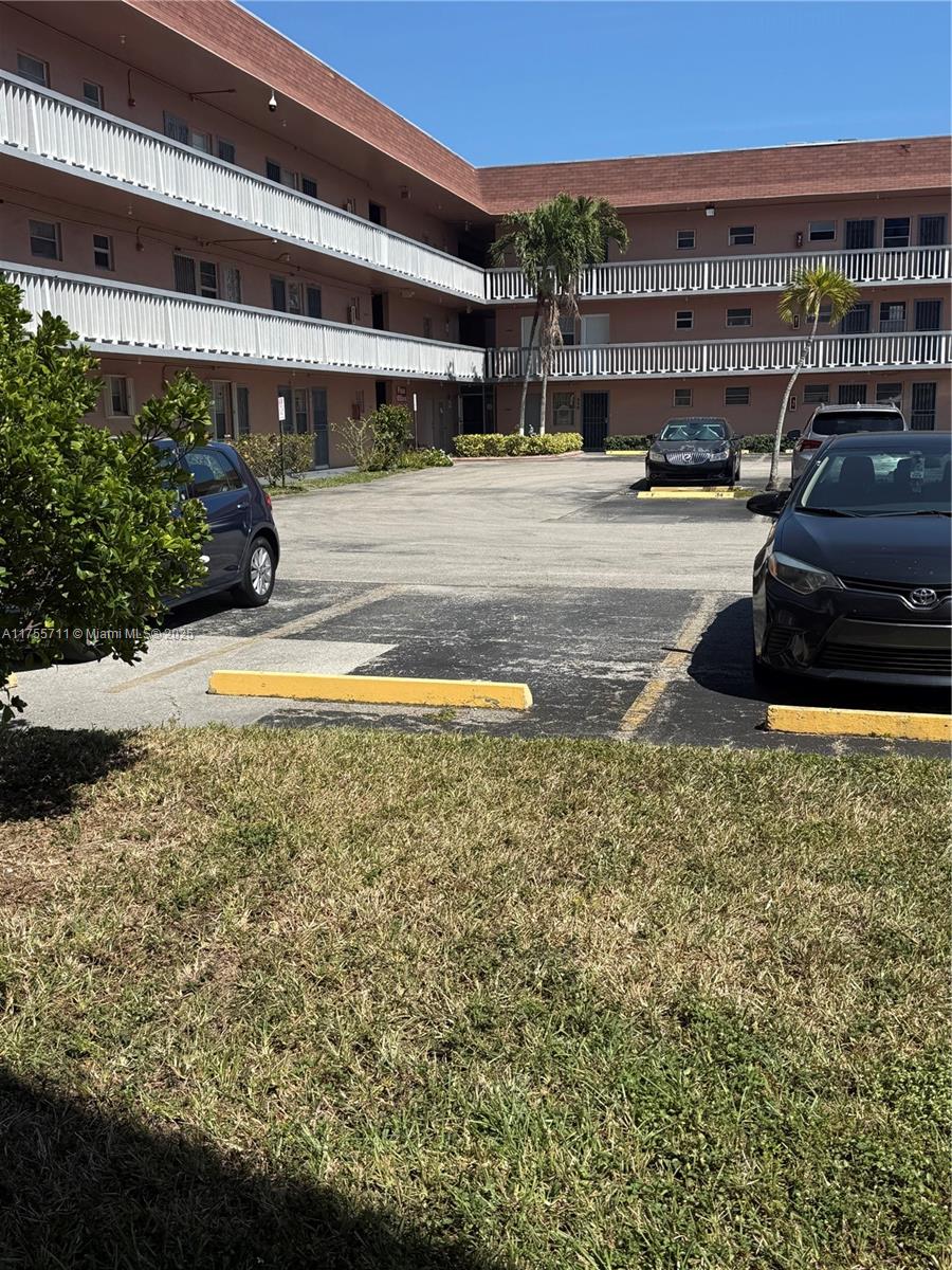 An exterior view of a multi-story apartment building with a parking lot in front — 18555 NE 14th Ave # B, Miami FL 33179, MIAMI, FL
