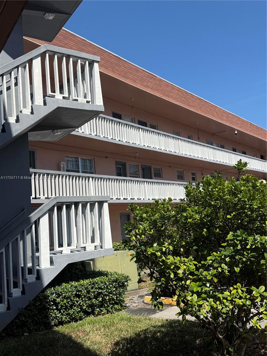 An exterior view of a multi-story apartment building with white railings and an outdoor staircase — 18555 NE 14th Ave # B, Miami FL 33179, MIAMI, FL