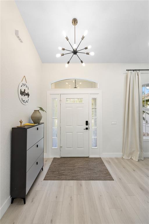 A bright dining area features light wood floors, a large table, and a front entryway — 5160 HORNBUCKLE BOULEVARD, NORTH PORT, FL