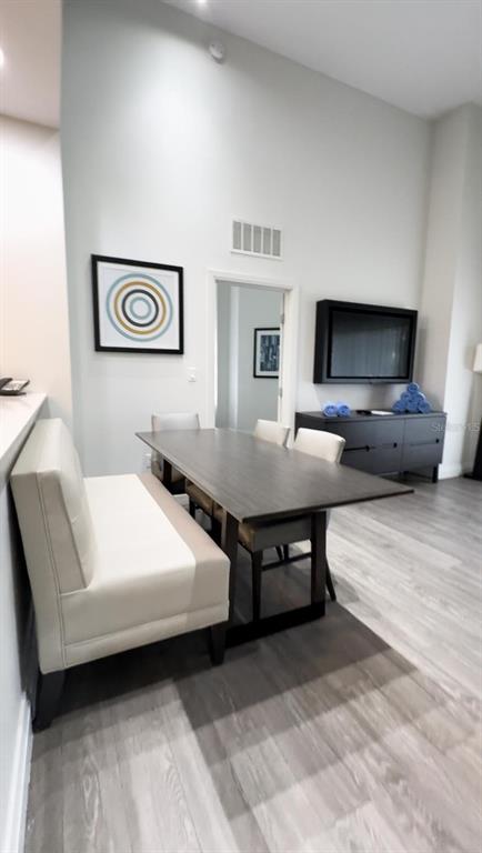 A dining area features a wooden table, a bench seat, and a wall-mounted television — 14501 GROVE RESORT AVENUE UNIT 3128, WINTER GARDEN, FL