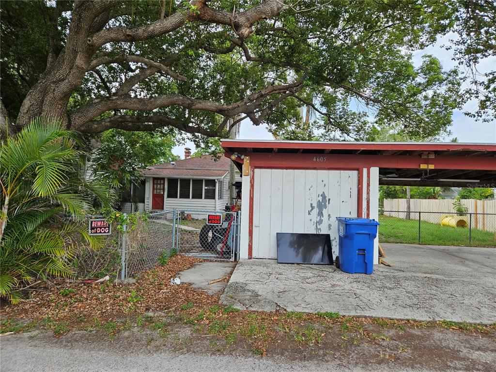 A small house with a detached garage and a chain-link fence under a large tree — 4605 8TH AVENUE N, ST PETERSBURG, FL