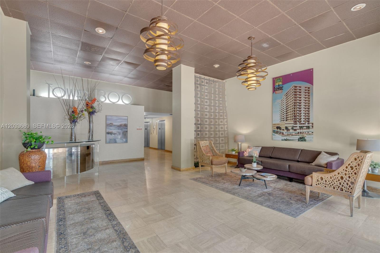 A lobby features a reception desk, seating area, patterned ceiling, and two large pendant lights — 1800 Collins Ave # 10F, Miami Beach FL 33139, MIAMI BEACH, FL