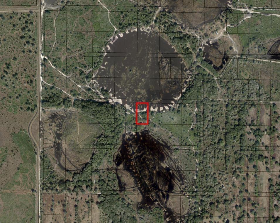 This aerial map shows a red rectangle highlighting a plot of land between two ponds — 0 NW 300th Street, Okeechobee FL 34972, OKEECHOBEE, FL