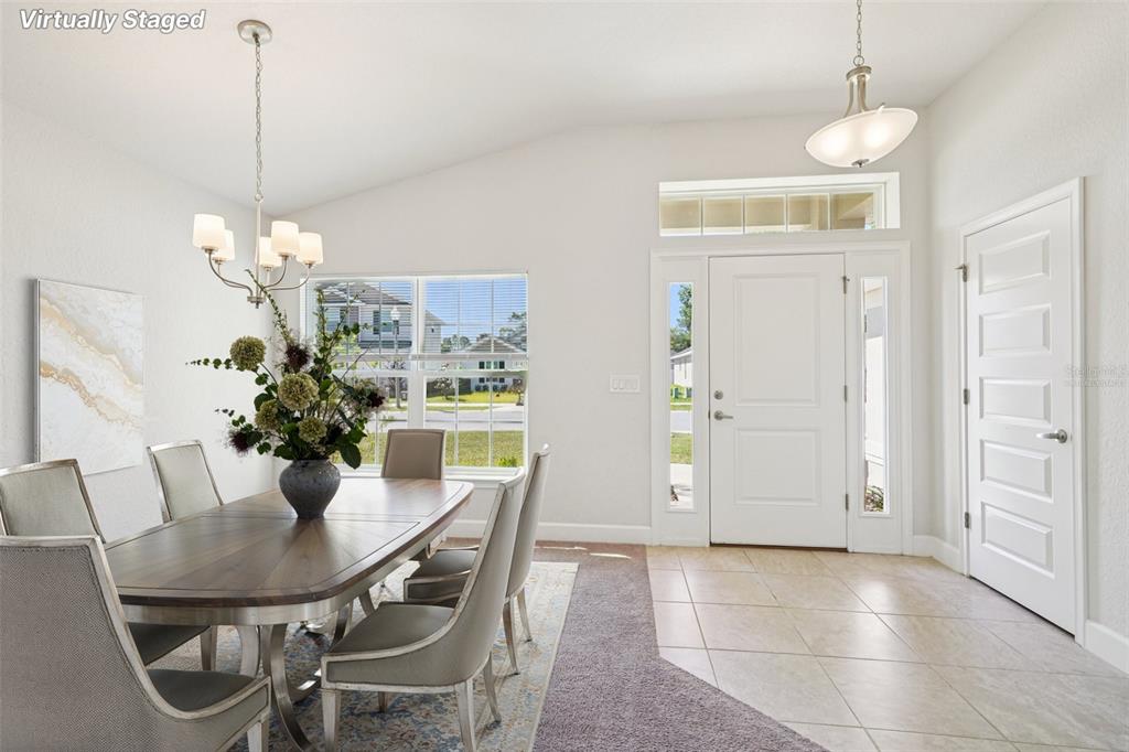 A dining area with a wooden table and chairs sits beside a tiled entryway — 4588 SE 25TH LOOP, OCALA, FL