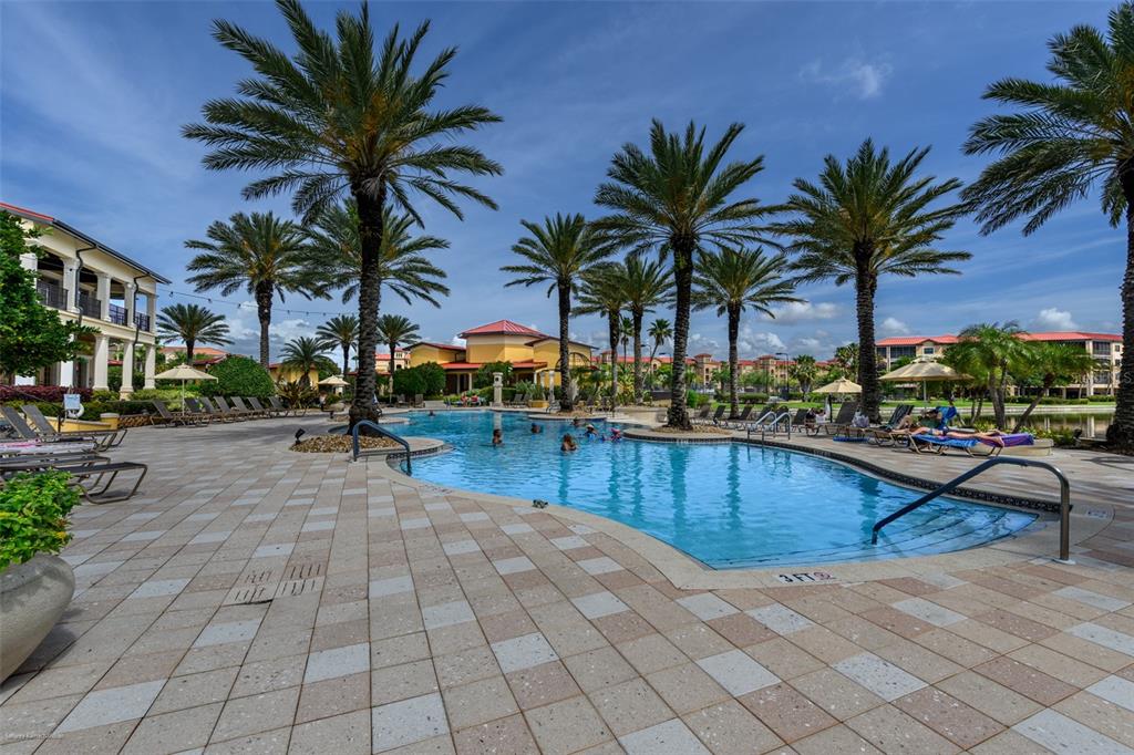 A swimming pool surrounded by palm trees and lounge chairs at a resort-style complex — 89 VIVANTE BOULEVARD UNIT 402, PUNTA GORDA, FL