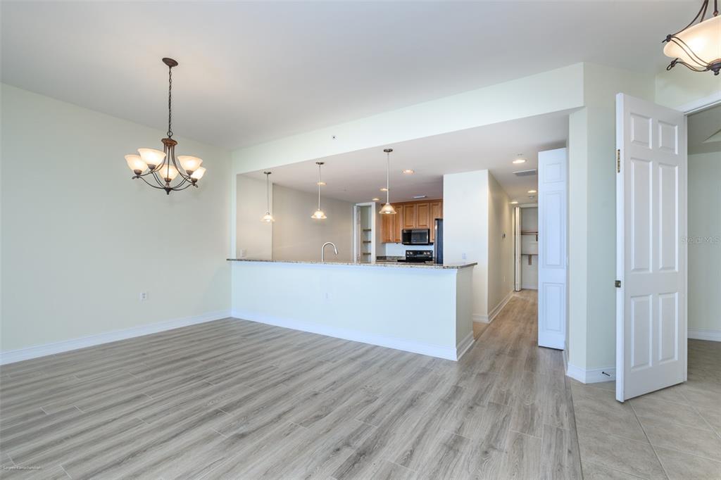 A dining area with a chandelier opens to a kitchen featuring a breakfast bar — 89 VIVANTE BOULEVARD UNIT 402, PUNTA GORDA, FL