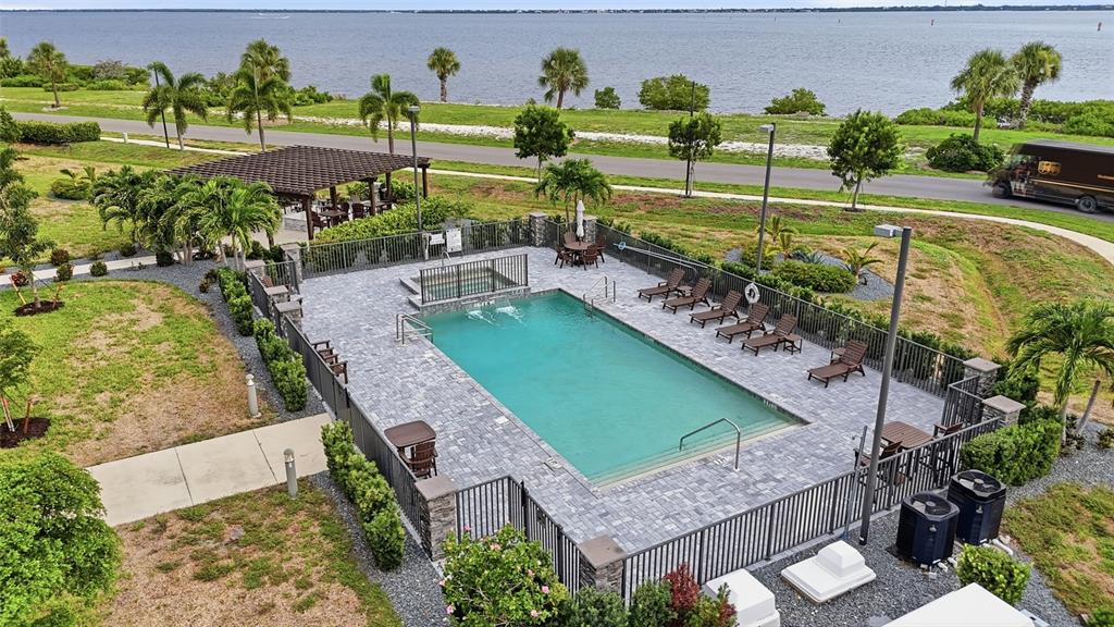 An aerial view of a rectangular swimming pool with a hot tub and patio furniture — 1425 PARK BEACH CIRCLE UNIT 1310, PUNTA GORDA, FL
