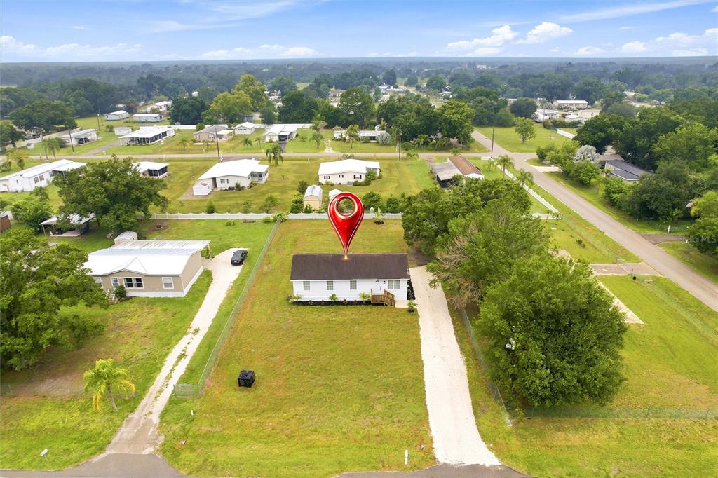 An aerial view shows a single-story house with a white exterior and a dark roof — 2419 SW HILLSBOROUGH AVENUE, ARCADIA, FL