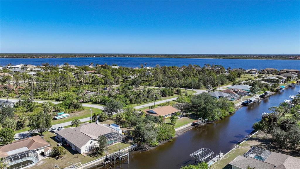 An aerial view shows houses along a canal leading to a large body of water — 3455 MONTGOMERY DRIVE, PORT CHARLOTTE, FL