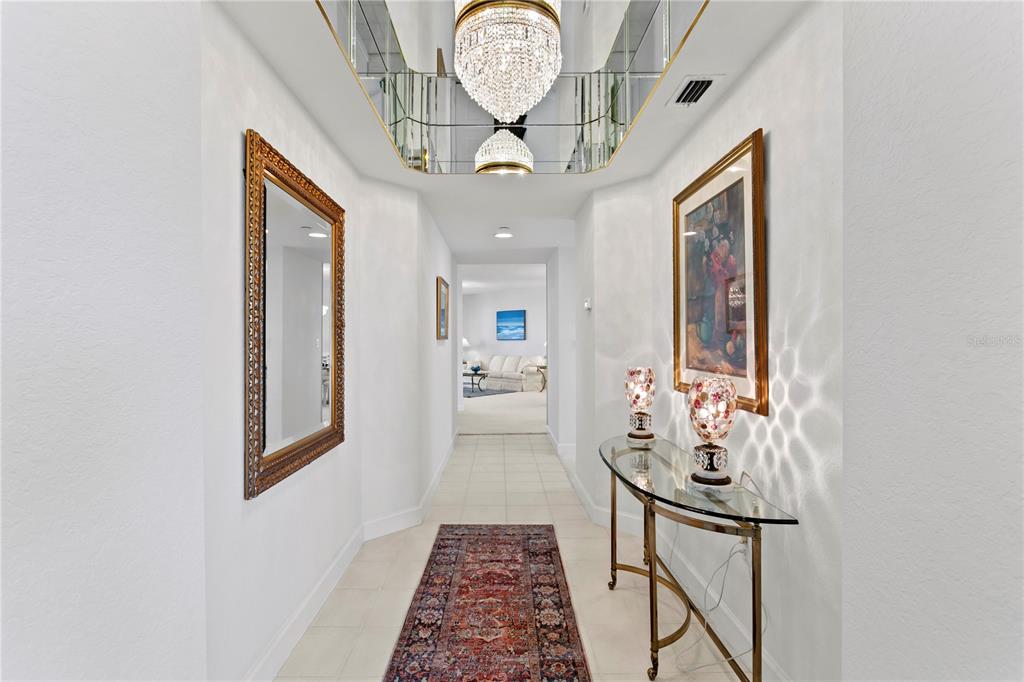 A balcony with floral-patterned patio furniture overlooks a large body of water — 4971 BACOPA LANE S UNIT 703, ST PETERSBURG, FL