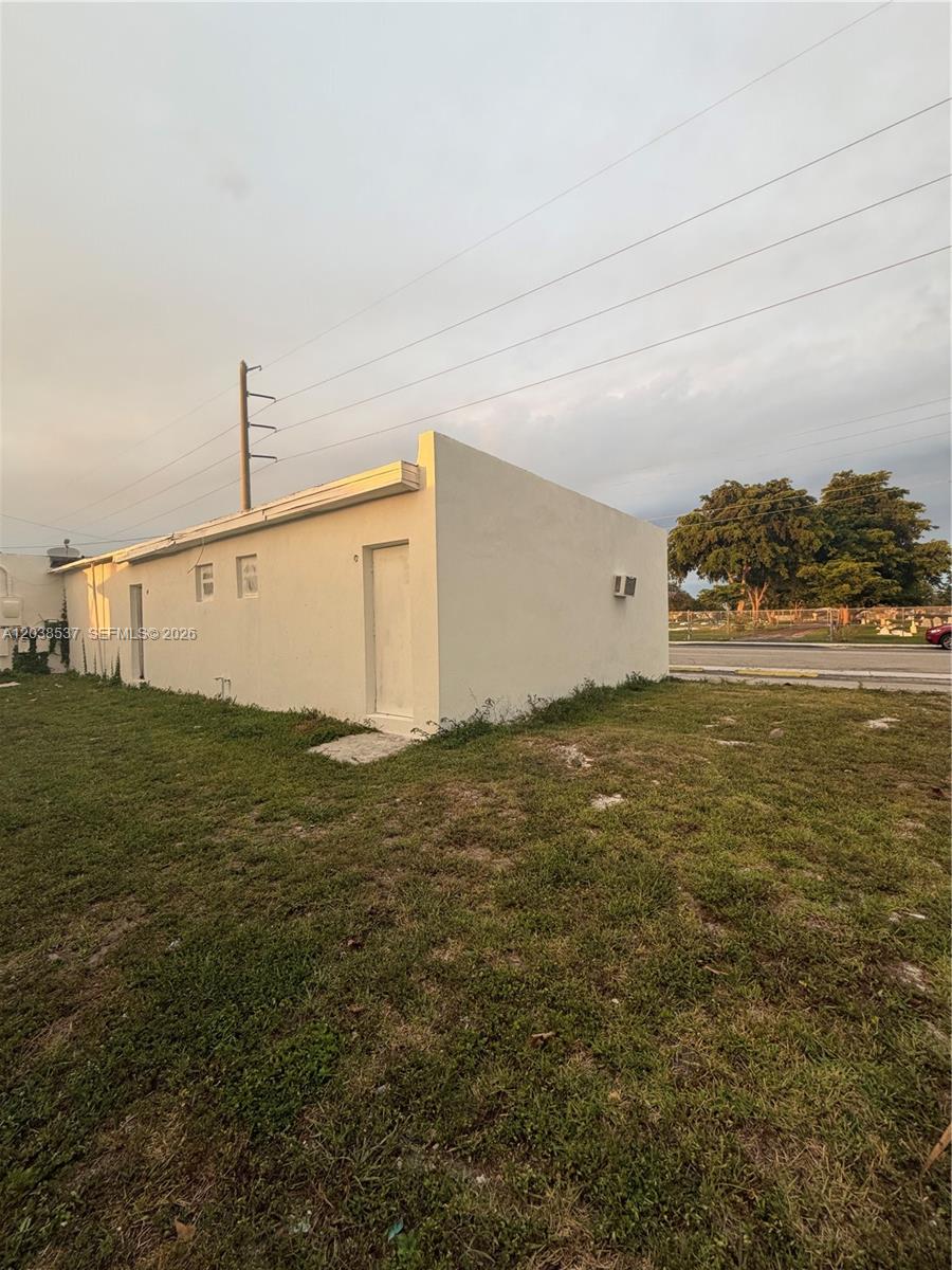 A plain, light-colored exterior wall of a small building sits on a grassy lot — 2910 N 22nd Ave, Hollywood FL 33020, HOLLYWOOD, FL