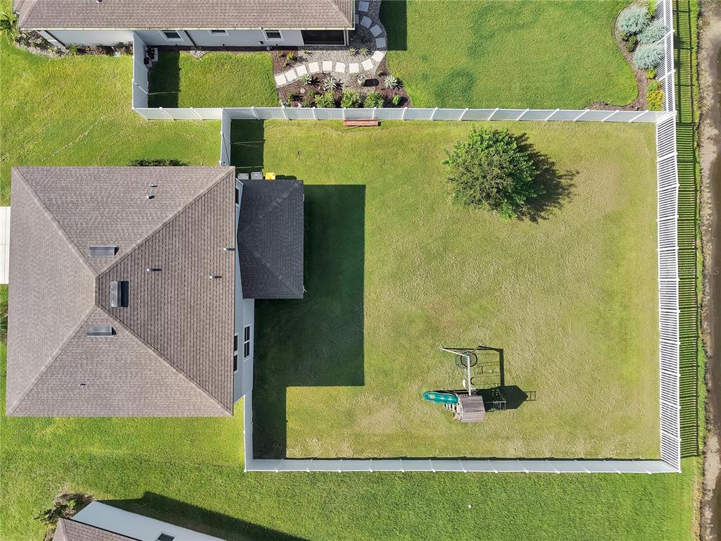 An aerial view shows a house with a large fenced backyard containing a playset — 1042 MICHELANGELO LANE, WINTER HAVEN, FL