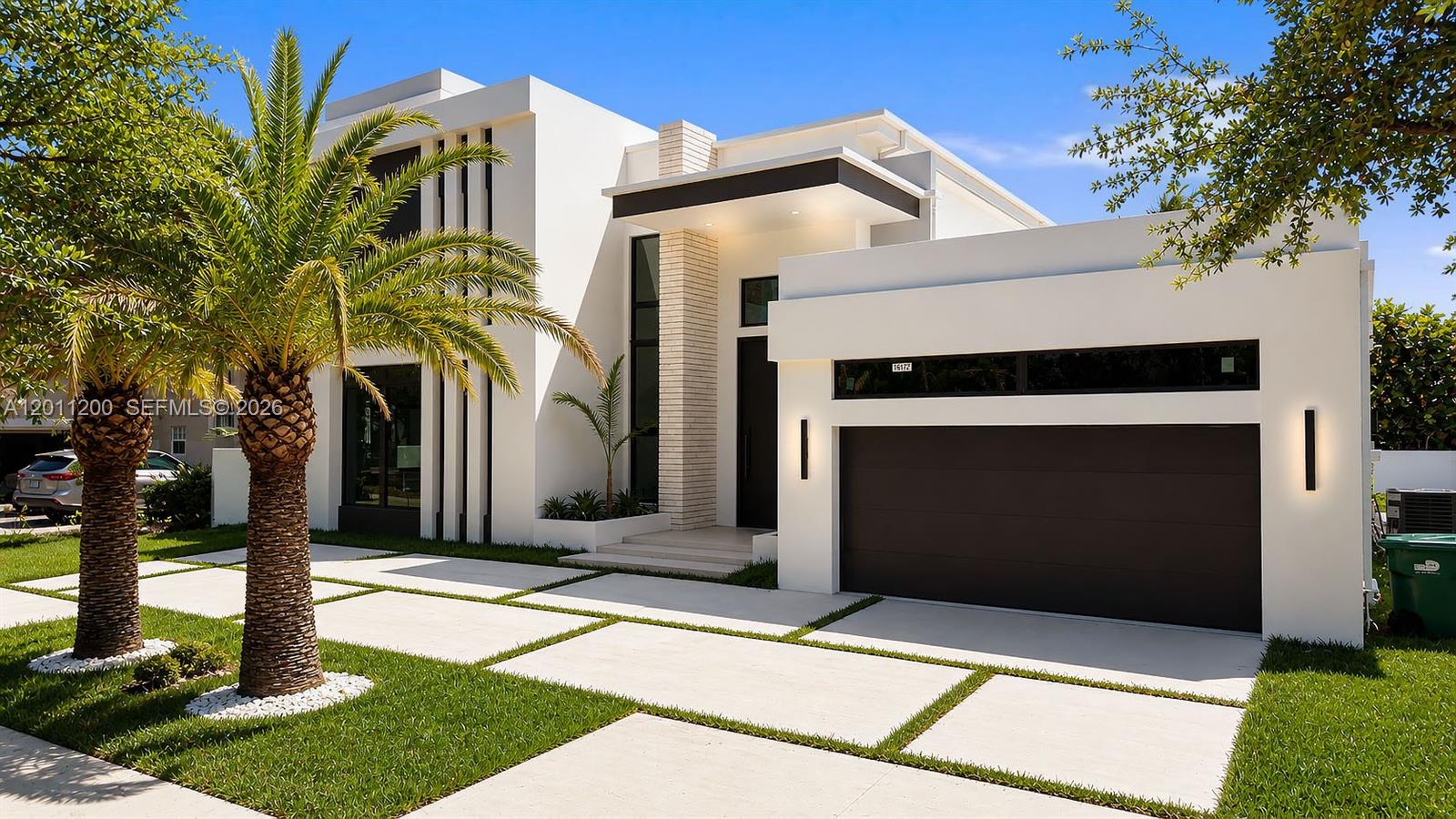 A modern white house with a flat roof, a dark garage door, and palm trees — 16022 NW 83rd Ct, Miami Lakes FL 33016, MIAMI LAKES, FL